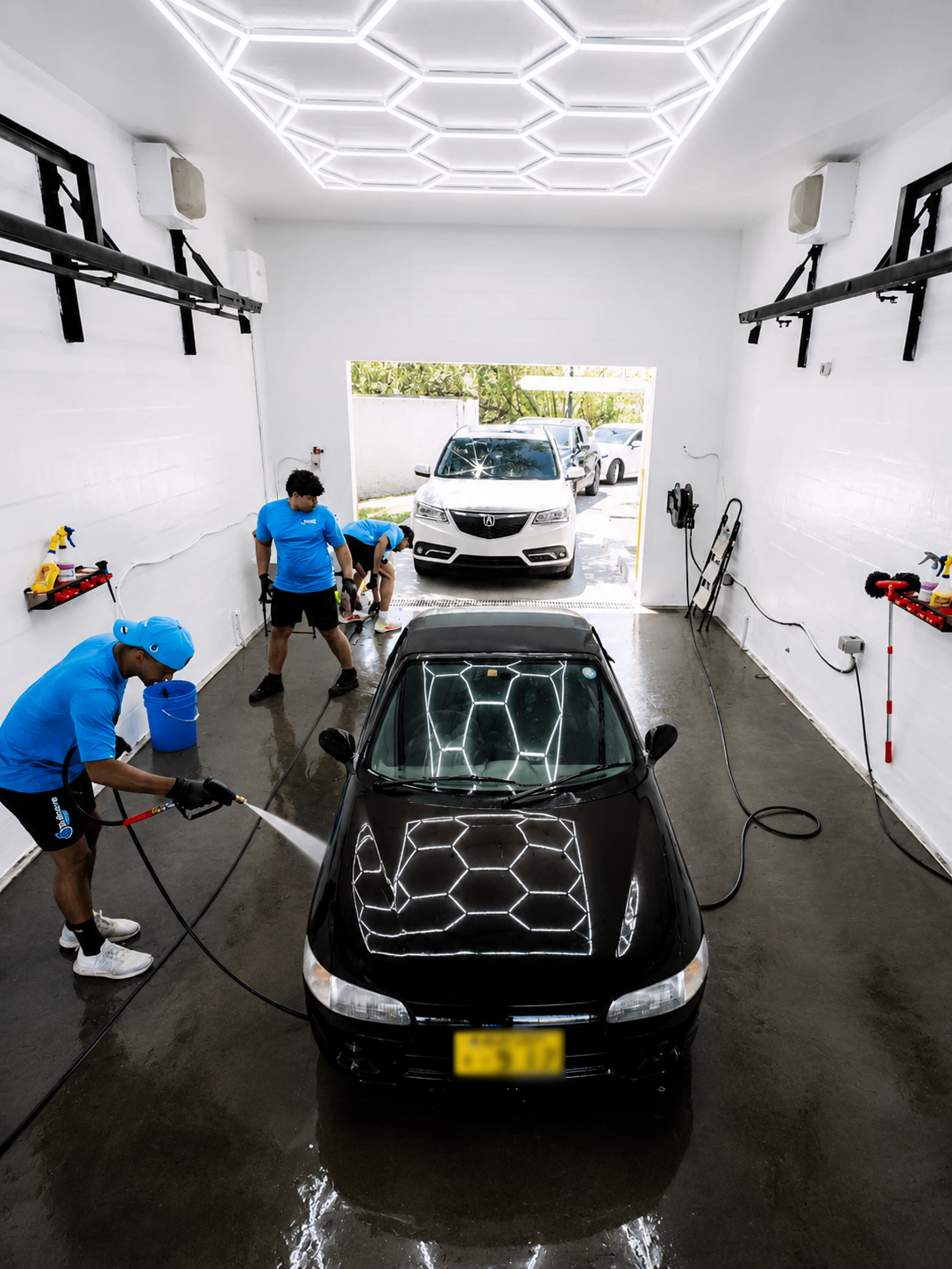 Vista cenital del área de lavado con luces LED hexagonales y técnicos trabajando